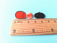 Load image into Gallery viewer, Baked bean enamel pin next to a ruler as a size guide. It measures approximately 1.7cm