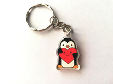 Load image into Gallery viewer, Mini cute penguin keyring. Made from recycled acrylic. The penguin is holding a big red heart which has a smiley face.