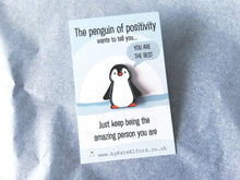 Load image into Gallery viewer, A little penguin enamel pin on a backing card with the wording the penguin of positivity wants to tell you, you are the best. Just keep being the amazing person you are. It is a black and white penguin with orange feet and beak