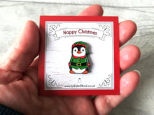 Load image into Gallery viewer, Elf penguin enamel pin. Penguin is wearing a red and green outfit and hat, the backing card reads Happy Christmas