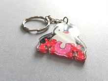 Load image into Gallery viewer, Mum penguin acrylic keyring. The penguin is holding the word mum in big red and pink polka dot letters. Made from recycled acrylic and the photo is taken at an angle to show the light catching how smooth and shiny the acrylic is.