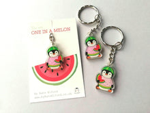 Load image into Gallery viewer, Mini recycled acrylic keyring. A little penguin holding a slice of watermelon, dressed in a pink, yellow and green watermelon jumper. With a green watermelon hat. The wording on the backing card reads you are one in a melon.