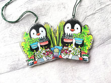 Load image into Gallery viewer, Penguin and house plants recycled acrylic hanger. There are two together to show it is the same image on both sides.