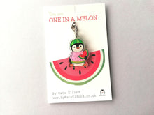 Load image into Gallery viewer, Small penguin recycled acrylic key fob. A penguin holding a slice of watermelon with a bite out of it, and dressed in a watermelon jumper. Wearing a watermelon hat. The wording on the backing card reads you are one in a melon.