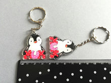 Load image into Gallery viewer, Mum penguin keyring gift. The penguin is holding the word mum in red and pink spotty letters. Made from recycled acrylic and sat next to a ruler as a size guide. It measures approximately 4cm tall.