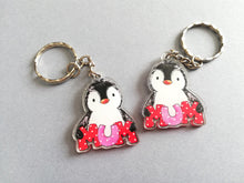 Load image into Gallery viewer, An acrylic penguin keyring holding the word mum in red and pink spotty dot letters. Made from recycled acrylic. There are two keyrings in the photo showing it is the same reversed design on both sides