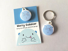 Load image into Gallery viewer, Worry gobbler mini round keyring. A blue cute blob character on a backing card with the words worry gobbler carry me with you wherever you go