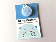 Load image into Gallery viewer, Worry gobbler mini round keyring. Blue cute blob character displayed on a backing card with the words worry gobbler carry me with you wherever you go