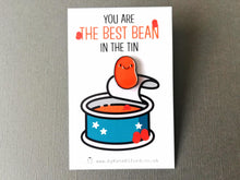 Load image into Gallery viewer, Best bean baked bean enamel pin. A little orange smiley baked bean pin. The backing card has the picture of a  blue baked bean tin and the words you are the best bean in the tin above