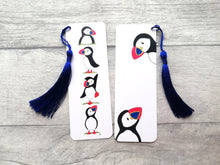 Load image into Gallery viewer, Puffin bookmark. White bookmark with puffin illustrations. There is a blue tassel attached to the top