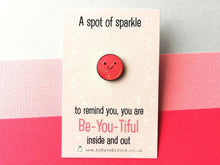 Load image into Gallery viewer, A little round pink glittery enamel pin with a sparkly happy face.
The wording on the card reads a spot of sparkle to remind you, you are Be You Tiful inside and out