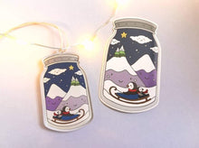 Load image into Gallery viewer, Penguin recycled acrylic hanger and sticker, happy mountains and snow, sledging in the snow