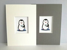 Load image into Gallery viewer, Cute black and white penguin, wearing blue pom pom slippers and holding tea, in a blue polka dot cup and saucer. Available in a coice of 7 x 5 inch grey or white mount