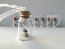 Load image into Gallery viewer, Miniature penguin decoration. Little pottery penguin chick in a glass bottle. Christmas mini penguin ornament