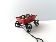 Load image into Gallery viewer, Miniature penguins in a cart. Little pottery penguin chicks in a red truck. Cute penguins