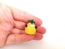 Load image into Gallery viewer, Penguin pineapple. Little penguin in a box, black and white miniature pottery penguin in a yellow pineapple, ceramic quirky penguin gift