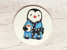 Load image into Gallery viewer, Penguin coaster. Penguin is wearing a polka dot blue dressing gown, slippers and having a cup of tea
