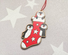 Load image into Gallery viewer, Penguin Christmas stocking decoration. Wooden penguins Christmas tree ornament. Red and white stocking with stars, eco friendly wood