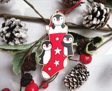 Load image into Gallery viewer, Penguin Christmas stocking decoration. Wooden penguins Christmas tree ornament. Red and white stocking with stars, eco friendly wood