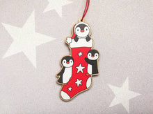 Load image into Gallery viewer, Penguin Christmas stocking decoration. Wooden penguins Christmas tree ornament. Red and white stocking with stars, eco friendly wood