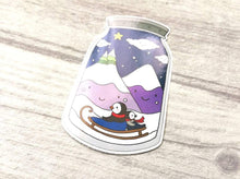 Load image into Gallery viewer, Penguin winter jam jar vinyl stickers, cute penguin sticker, mountains, sledging cute sticker, winter scene in a jam jar