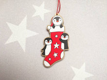 Load image into Gallery viewer, Penguin Christmas stocking decoration. Wooden penguins Christmas tree ornament. Red and white stocking with stars, eco friendly wood