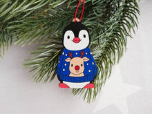 Load image into Gallery viewer, Penguin reindeer jumper decoration. Little wooden penguin wearing a blue or red jumper Christmas ornament, responsibly resourced wood