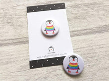 Load image into Gallery viewer, Mini button badge. A small round badge with a white background. The picture is a black and white penguin wearing a rainbow colour striped jumper
