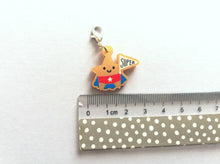 Load image into Gallery viewer, Gold acrylic star, a gold star for a super star stitch marker. The star has a smile and is wearing a blue cape and red pants, holding a flag saying super