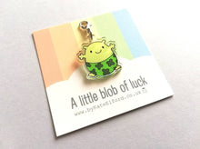 Load image into Gallery viewer, A little blob of luck stitch marker. Recycled acrylic charm with a silver plated lobster clasp. Blob is a happy little character wearing four leaf clover lucky pants.