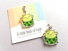 Load image into Gallery viewer, A little blob of luck stitch marker. Recycled acrylic charm with a silver plated lobster clasp. Blob is a happy little character wearing four leaf clover lucky pants.

