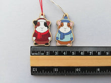 Load image into Gallery viewer, Guinea pig Christmas little decorations. Ethically sourced eco friendly. Choice of blue or red. Cute Christmas tree ornaments.