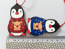 Load image into Gallery viewer, Penguin reindeer jumper decoration. Little wooden penguin wearing a blue or red jumper Christmas ornament, responsibly resourced wood