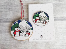Load image into Gallery viewer, Penguin Christmas decoration. Snowy mountains small wooden ornament. Ethically sourced wood. Cute penguins Christmas tree ornaments.