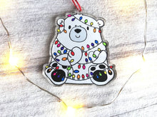 Load image into Gallery viewer, Polar bear Christmas tree decoration. Recycled acrylic Christmas ornament, polar bear tangled up in rainbow coloured fairy lights