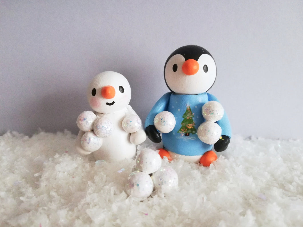 Penguin and snowman snowball fight