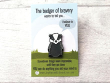 Load image into Gallery viewer, A badger enamel pin by Kate Elford. The backing card has the wording the badger of bravery wants to tell you I believe in you. Sometimes things seem impossible until they are done. You can do anything you set your mind to
