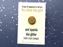 Load image into Gallery viewer, A mini gold glitter round enamel pin with a happysmiling face. It is on a rectangular backing card which has the wording a spot of happiness to tell you you shine like gold and sparkle like glitter. Don&#39;t ever change. Designed by Kate Elford
