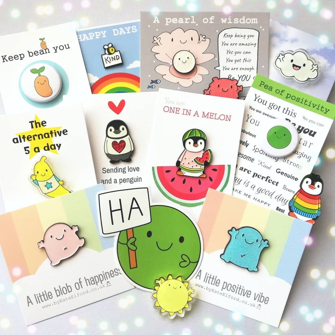 A mix of lots of badges, magnets, and stickers by Kate Elford. There are beans, peas, penguins, sunshine, bees and a blob of happiness