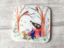 Load image into Gallery viewer, Badger sat under a tree in winter talking to two robins. Printed on to a glossy square coaster
