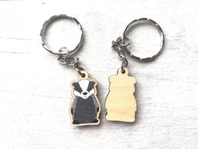 Load image into Gallery viewer, Front and back of a mini badger keyring. The back is shown and is plain wood
