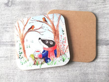 Load image into Gallery viewer, Badger sat under a tree with two robins. Winter countryside design with snowdrops. Square glossy small coaster
