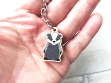 Load image into Gallery viewer, Very mini wooden badger keyring in a hand as a size guide
