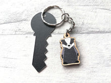 Load image into Gallery viewer, A mini badger keyring next to a real key size tag to show the size
