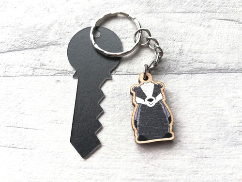 A mini badger keyring next to a real key size tag to show the size