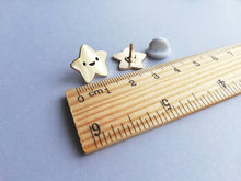 Load image into Gallery viewer, Mini gold star enamel pins sat next to a ruler. The stars measure 1.7cm across
