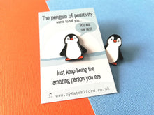Load image into Gallery viewer, A little penguin enamel pin on a backing card with the wording the penguin of positivity wants to tell you, you are the best. Just keep being the amazing person you are. There is a little penguin pin peeking out from behind the card

