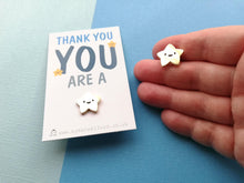 Load image into Gallery viewer, Small gold star metal enamel pin. The cute star has five points and a happy face. It is displayed on a mini white rectangular backing card with the wording thank you you are a at the top and the star pin is attached at the bottom
