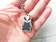 Load image into Gallery viewer, A badger mini keyring shown in a hand as a size guide

