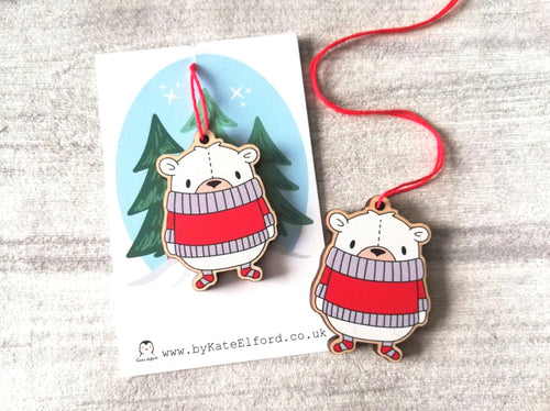 Little wooden polar bear Christmas tree decoration. The bear is wearing a red jumper, and little red and white stripey socks